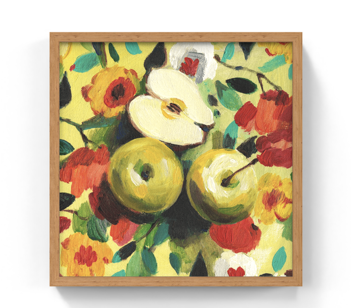 A framed still life painting of green apples and red flowers on a yellow background, shown in a light wood frame against a white wall.