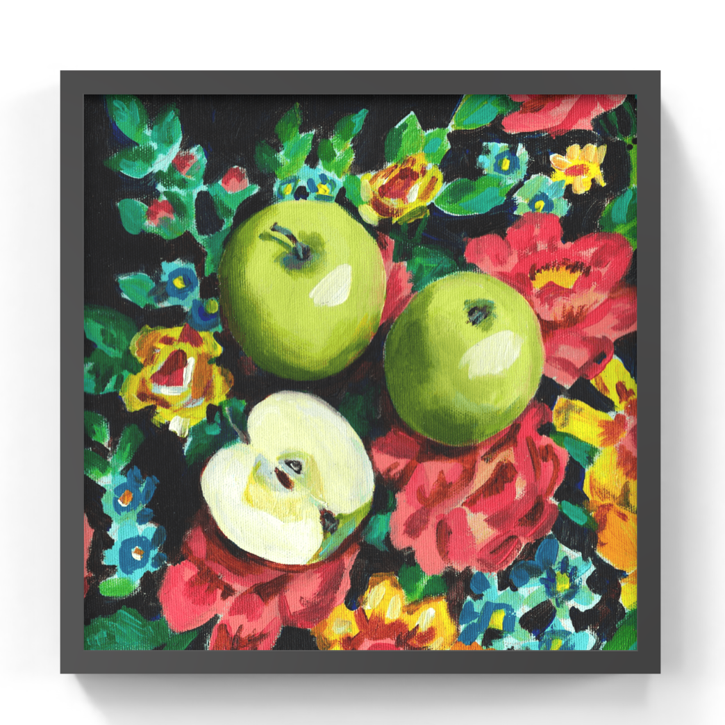 A framed still life painting featuring two green apples and a halved apple surrounded by colorful flowers on a dark background, presented in a square black frame against a white wall.