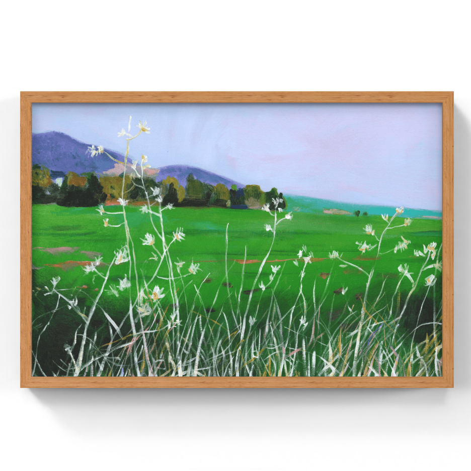A framed landscape painting of a green field with white wildflowers, trees, and distant purple mountains under a pale sky, shown against a white background.