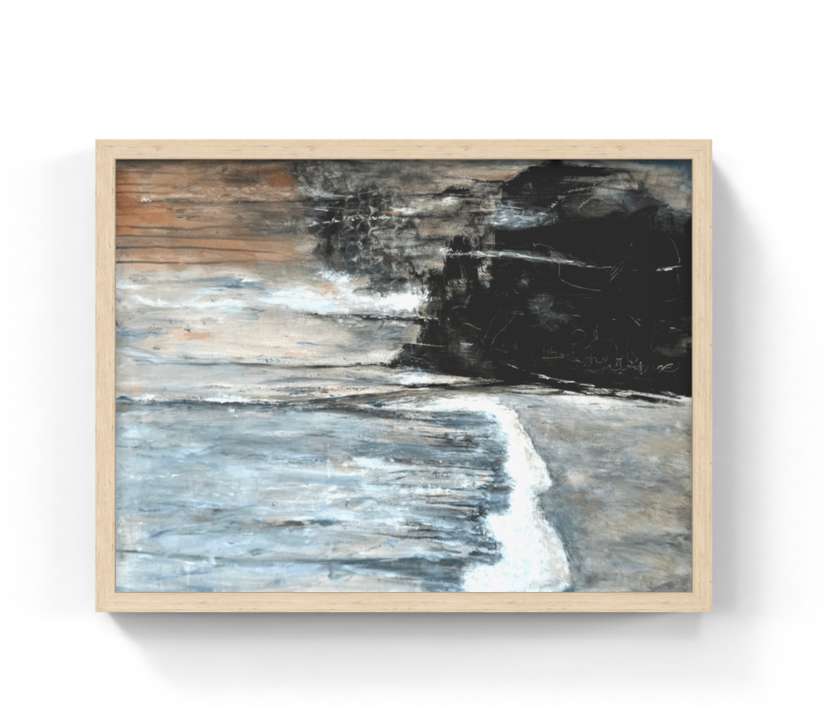 A framed abstract coastal painting featuring textured blue-gray water, white surf, and a dark black-and-brown shoreline, set in a light natural wood frame against a white wall.
